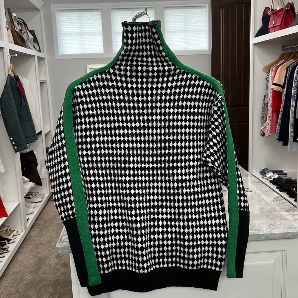 Black and white sweater with green stripe on side of sleeve. New with tag.